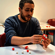 A teacher is manipulating useful objects to explain concepts