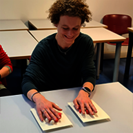 A student is having a tactile experience on a tabletop stand